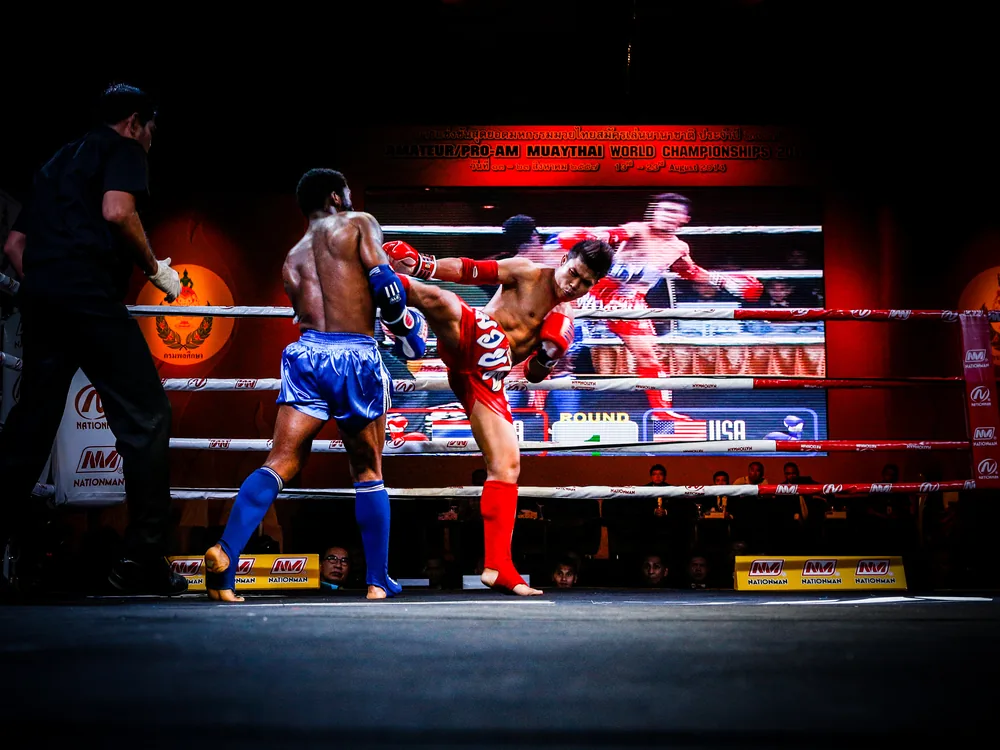 Two Muay Thai fighters exchanging strikes inside the ring
